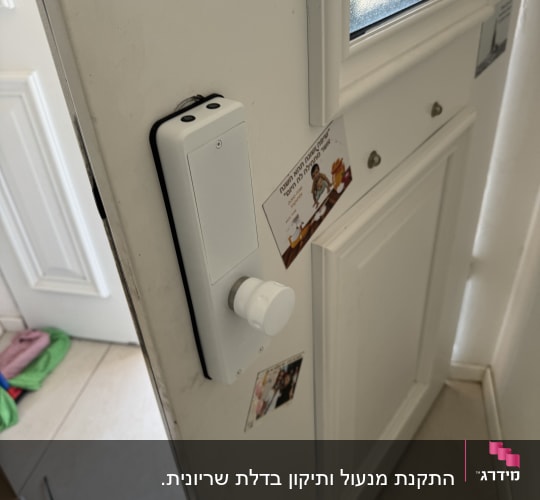 מנעול חכם מותקן על דלת לבנה עם ידית עגולה